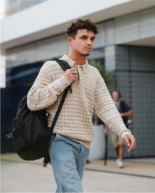 Lando in casual clothes walking through paddock