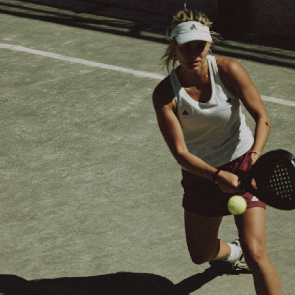 A woman playing paddle on a field in Lobb's Padel center